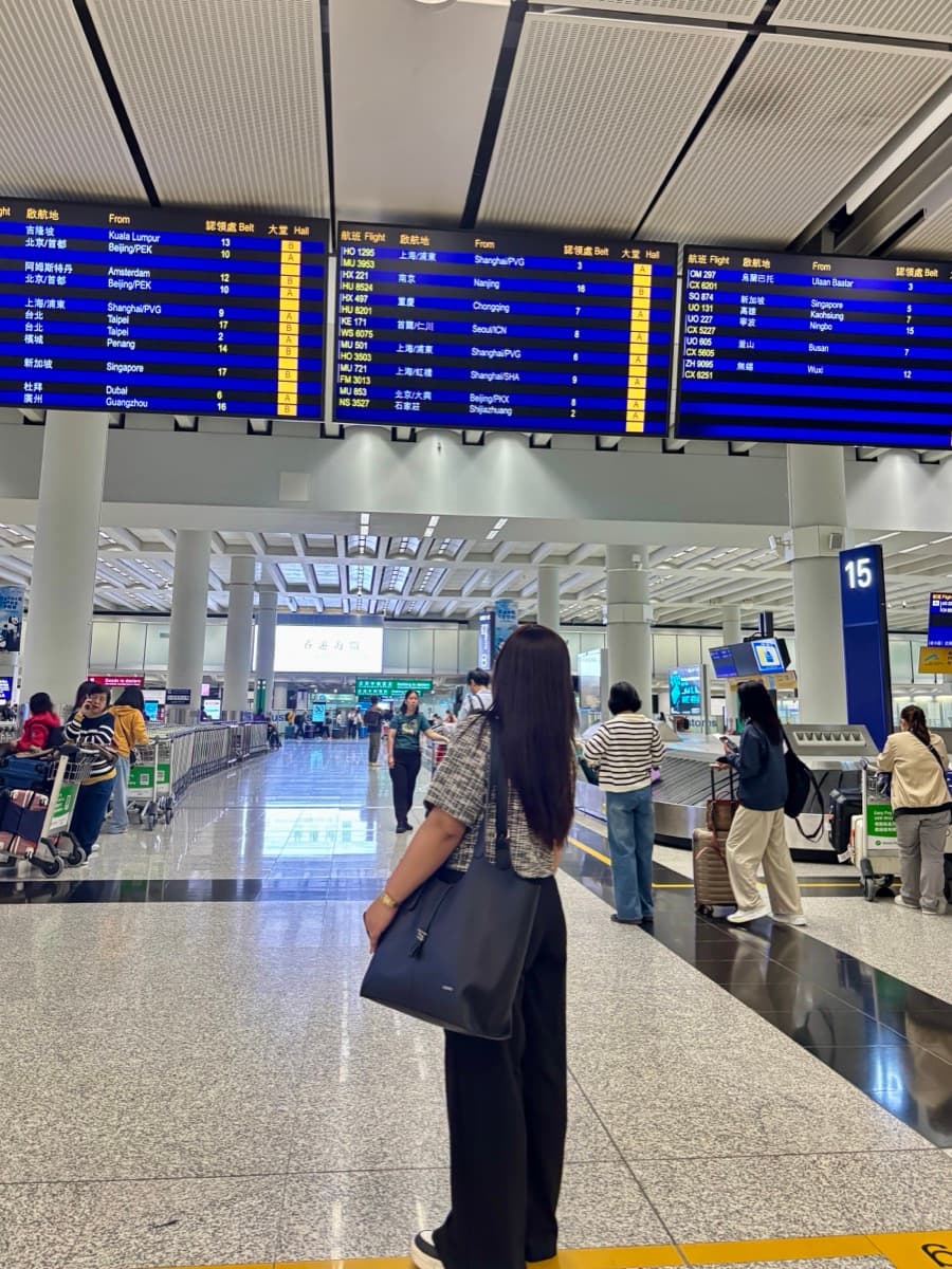 Mulher conferindo passaporte e documentos de viagem sentada com mala de mão em um aeroporto europeu