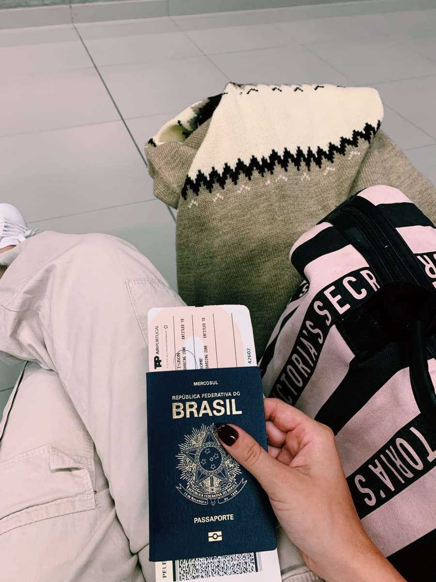 Mulher observando um mapa da Europa em uma mesa com café, calculadora e passaporte